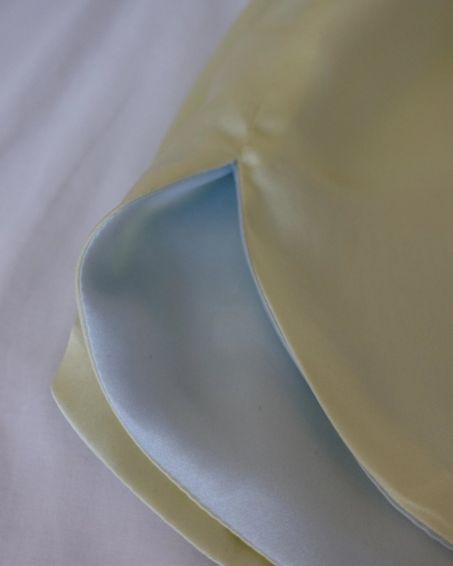 Close-up of the side slit on the blue and yellow Miti short, highlighting the reversible fabric and seam details