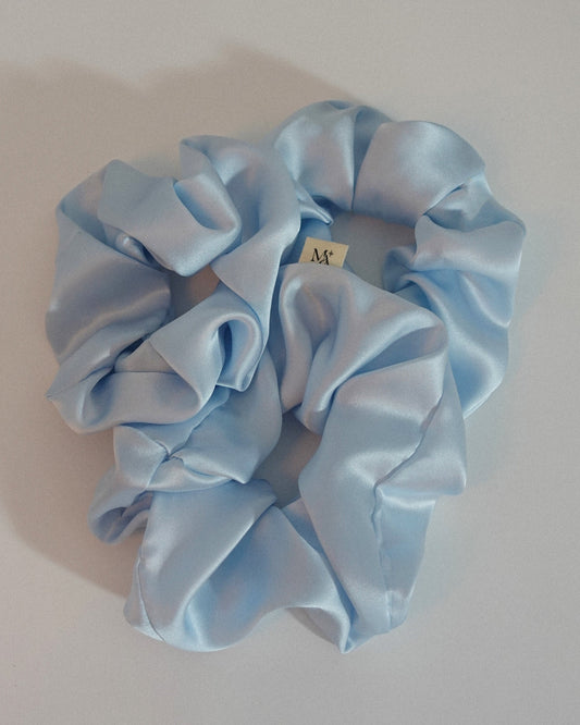 Light blue silk scrunchies on a white background