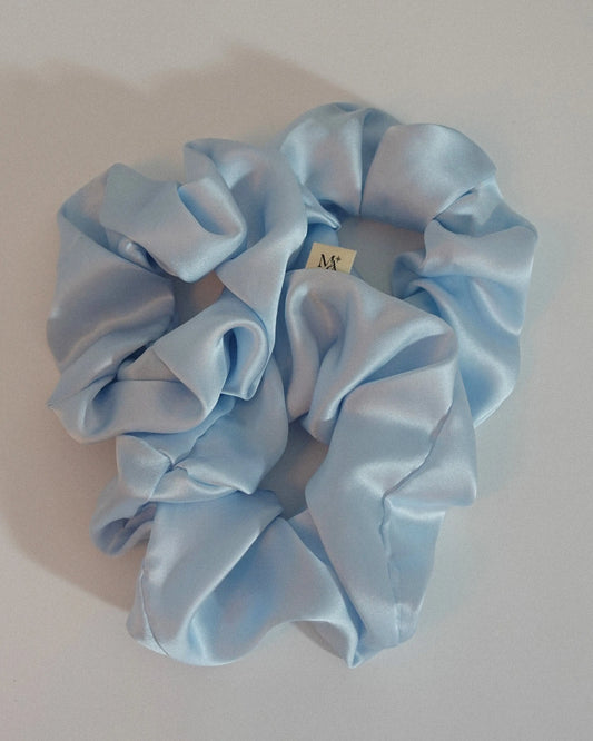 Light blue silk scrunchies on a white background