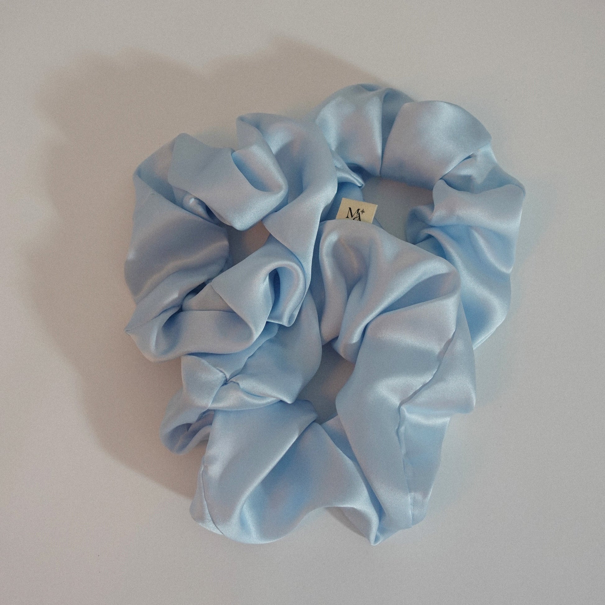 Light blue silk scrunchies on a white background