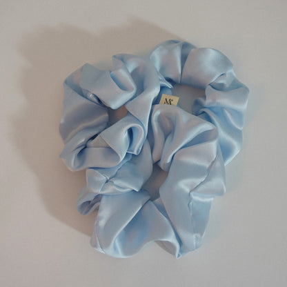 Light blue silk scrunchies on a white background