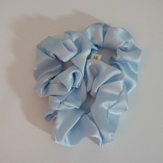 Light blue silk scrunchies on a white background