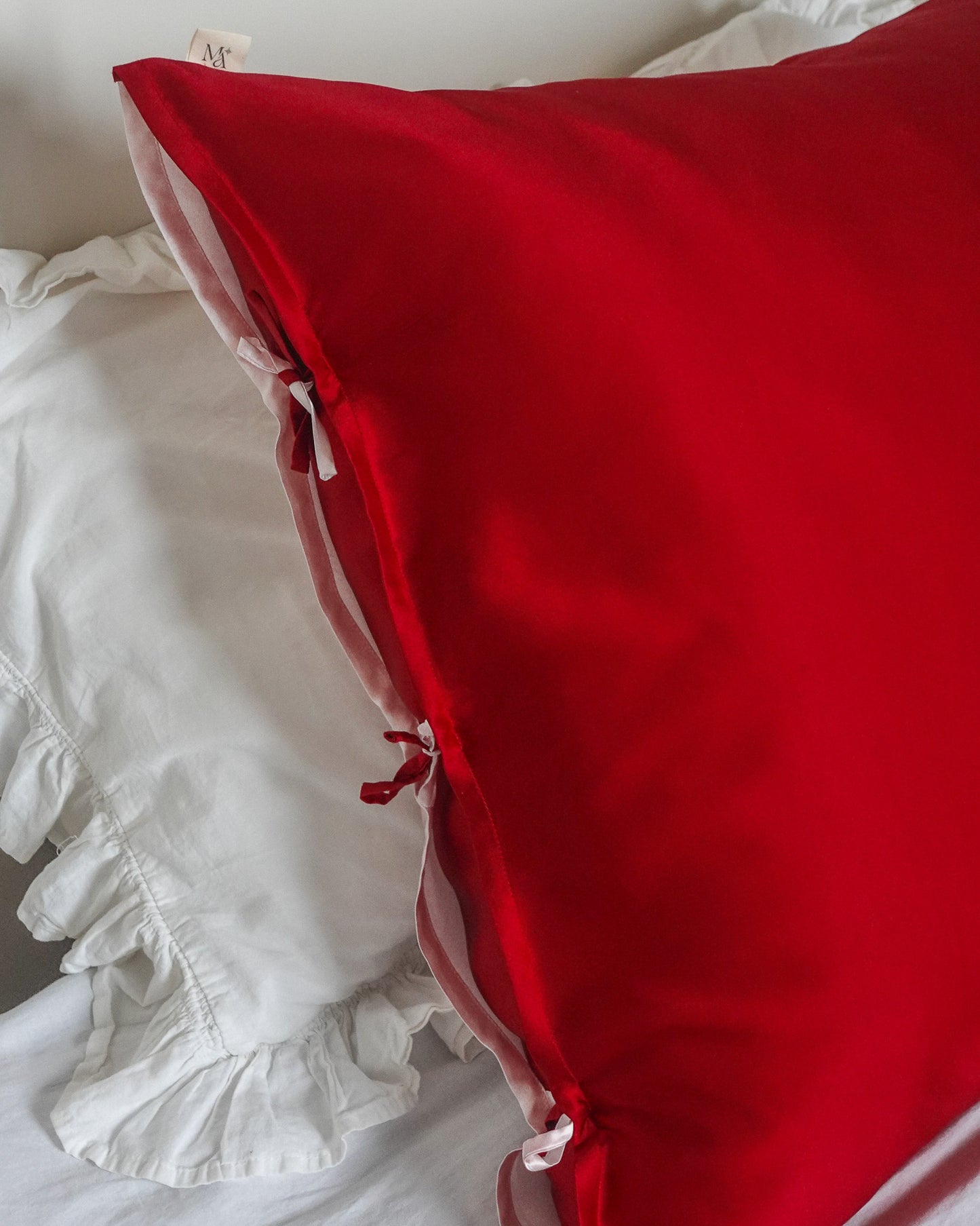 mulberry silk pillowcase with one red side and one pink side : closing with three ribbons.