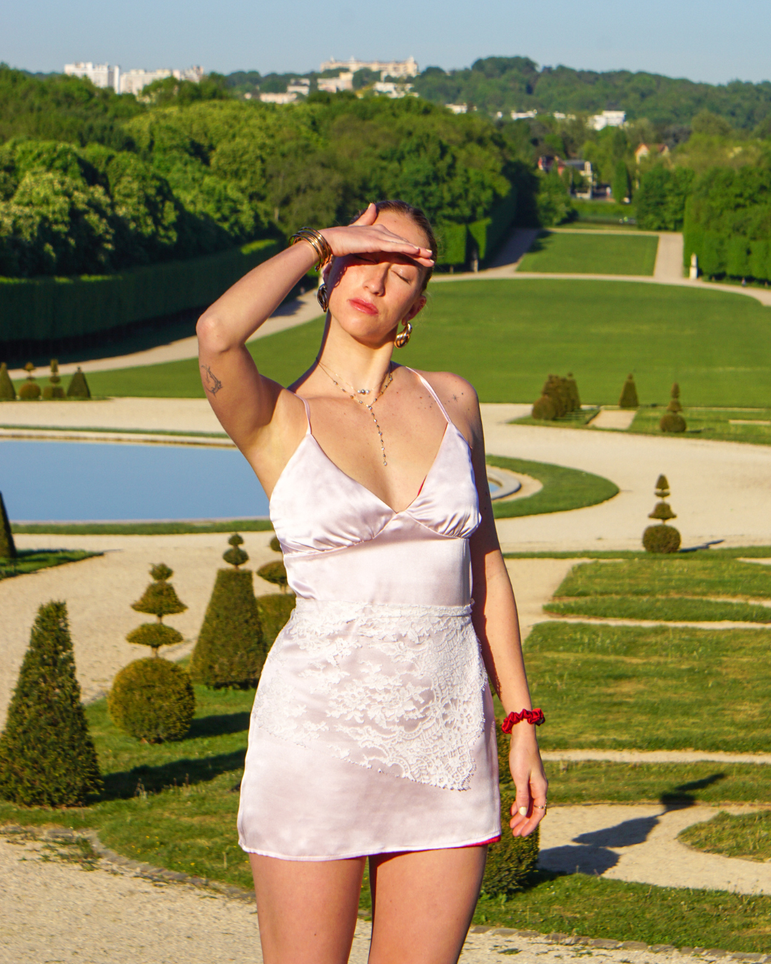 Woman wearing the reversible silk dress in a elegant park setting.