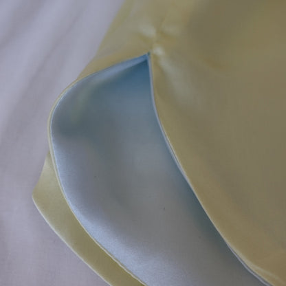 Close-up of the side slit on the blue and yellow Miti short, highlighting the reversible fabric and seam details